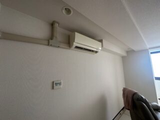 既存の壁とエアコンまわりは、経年劣化で汚れやくすみが目立っていました