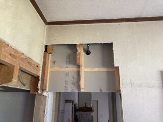 新しい壁面を作るために石膏ボードを張っています