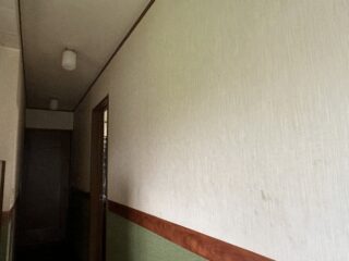 廊下の壁クロスの貼替え作業前の状態です